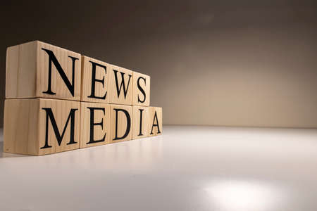 News text from wooden cubes. On a white background. Close-up.