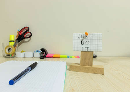 There is a notepad checker and pencil on the table. On the right side, it says on the paper, Just do...