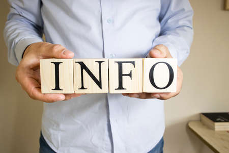 The word info written on wooden cubes held by hand. Close-up.の写真素材