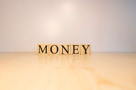 Money texts from wooden cubes. Photographs were taken on the wooden table.の写真素材