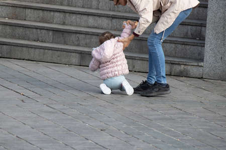 Istanbul, Turkey - October-27.2019: Little baby disagreeing with her mother. She doesn't want to walk.のeditorial素材