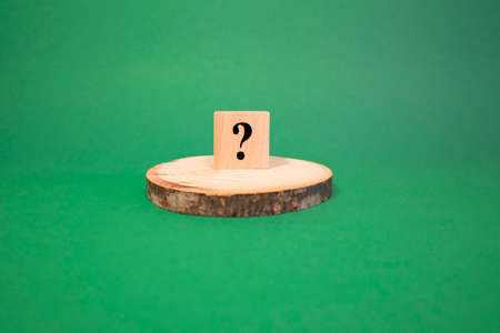 The word question mark made of wooden cubes. The background is green and photographed in the studioの写真素材