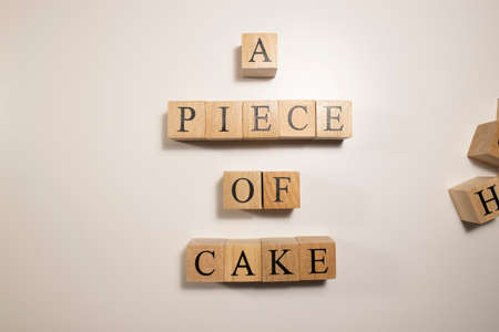 In terms of easy work, A piece of cake. Written from wooden cubes. White backgroundの写真素材