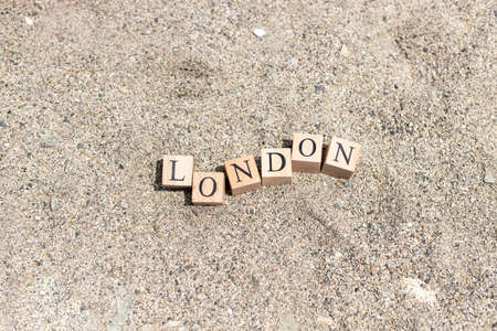 London word on wood cubes . On the beach sand by the sea.の写真素材