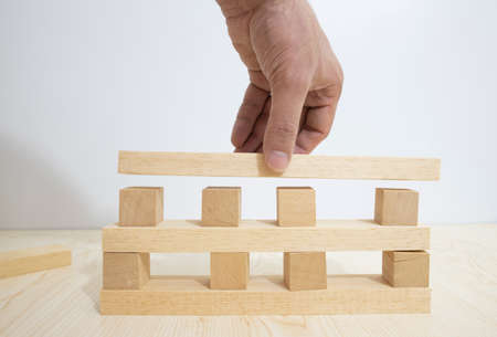 Building from wooden cubes and rods. The photo was taken on the white background and on the table.