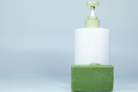 Olive oil liquid soap and solid soap in green color. Photographed on white background.