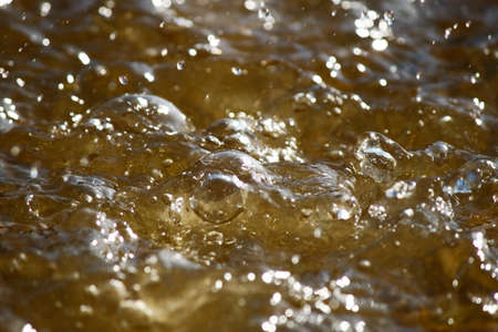 Waves and sunlight on the lake. The lake is brown.の写真素材