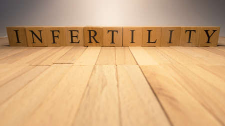 The word infertility was created from wooden letter cubes. Illness and health. close up.の写真素材