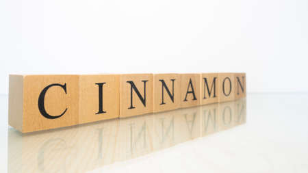The word Cinnamon was created from wooden letter cubes. Gastronomy and spices. close up.