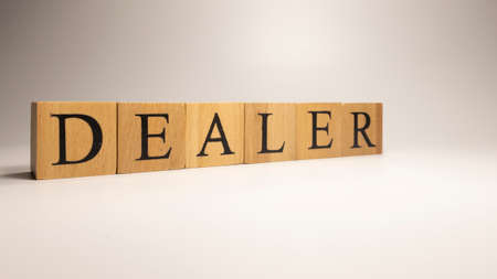 Dealer name was created from wooden letter cubes. Economics and finance.の写真素材