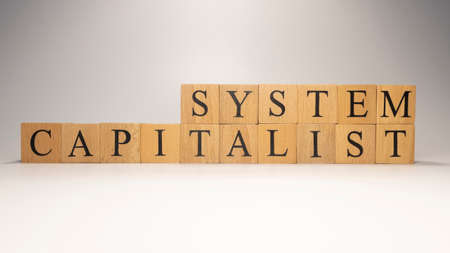 The name Capitalist system was created from wooden letter cubes. finance and economy. close up.の写真素材