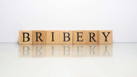 The name Bribery was created from wooden letter cubes. finance and illegal. close up.の写真素材