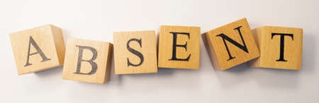 The word ABSENT was created from wooden cubes. work and life. close-up.の写真素材