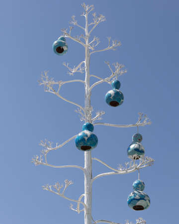 Close-up of tree branches and decorations painted on white. blue sky in the background