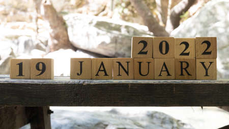 January was created from wooden cubes. Outdoors on table, trees in background. close up.の写真素材