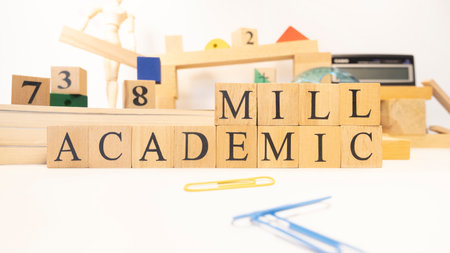 The word academic mill was created from wooden cubes. Close-up.の写真素材