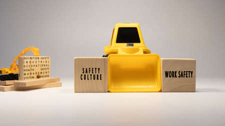 Safety culture, work safety , written on wooden sticks. Business machine and white background concept. Occupational safety and industry.の写真素材