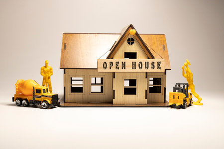 Open house word written on wooden surface. Workers working on wooden miniature house in the background. business and financeの写真素材