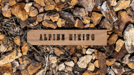 Alpine hiking written on wooden surface. Background stone pattern createdの写真素材