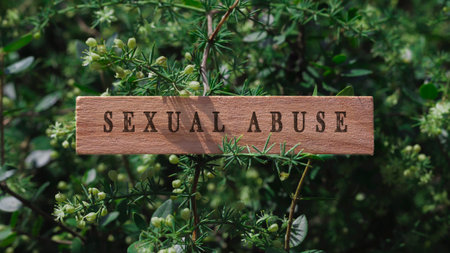sexual abuse. Written on wooden surface. Background tree leaves. Health and social problems.の写真素材