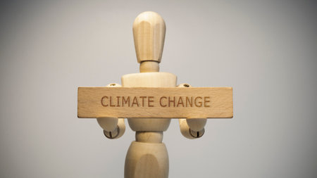The wooden man holding the sign Climate change written on it. social issuesの写真素材