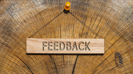 The word feedback is written on the wooden surface. wooden surface in background.の写真素材