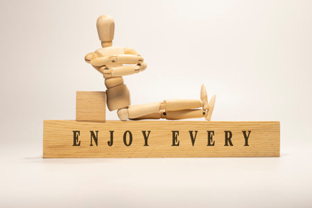 ENJOY EVERY MOMENT is written on the wooden surface. Wooden Concept.の写真素材