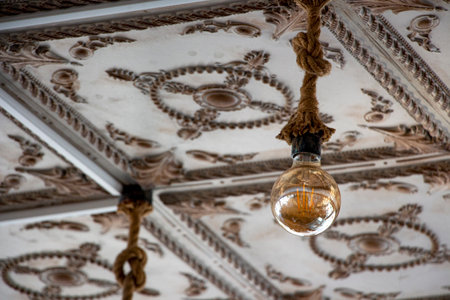 The vintage light bulb hanging on the ceiling of an old building. A Retro Edison light bulb hanging on the ceilingの写真素材