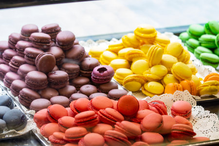 Colorful macarons on display in a shop window. Colorful macarons in showcase, patisserie, and sweet shop.の写真素材