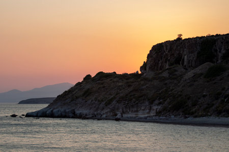 Sunset over the sea with rocks and mountains in the background. Sunset on the coast. Sunlight reflecting off the sea.の写真素材