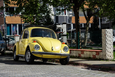 Yellow Beetle parked in the street. Old vintage car in the city