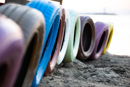 Colorful car tires on the beach. Selective focus with shallow depth of field. Close-up image with wheels in the coastline.の写真素材
