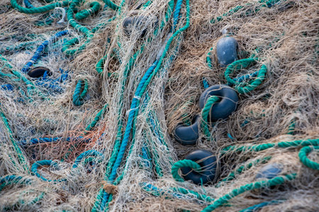Fishing nets on the pier in the evening light. Fishing nets and ropes on the beach. Fishing nets and...