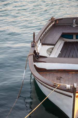 Wooden boat on the water in the port. Fishing boat on the water at sunset. Close-up of a fishing boat.の写真素材