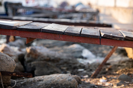 Wooden pier on the background of the sea and the city. Wooden pier on the shore of a lake with rocks...