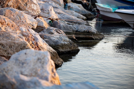 Fishing boats in the port. Boats in the bay at sunset. Fishing nets on the rocks in the port.の写真素材