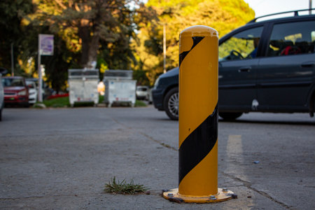 Yellow traffic barrier on the street in an urban area with cars in the background. Yellow and black traffic barrier on the street in a sunny day.の写真素材
