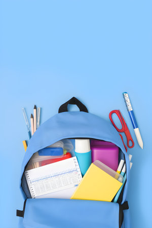 Blue backpack with school stationery on blue background, education day, international education day, Back to school concept,  with copyspace, for banner background.の素材