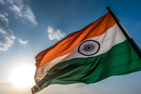India flag waving in the wind against the blue sky with sun rays, celebrates January 26th Republic day, August 15th independence day concept, for banner background.の素材
