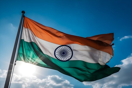 India flag waving in the wind against the blue sky with sun rays, celebrates January 26th Republic day, August 15th independence day concept, for banner background.の素材