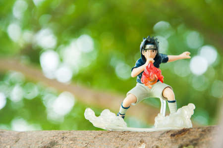BANGKOK - DECEMBER 07, 2014 : Figure of Naruto anime, Sasuke isblowing fire from his mouth on the tree on December 07, 2014 at Phuttabucha, Bangkok, Thailand.のeditorial素材