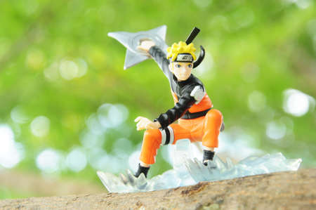 BANGKOK - DECEMBER 07, 2014 : A realism concept, A figure of Uzumaki Naruto in action throwing shuriken on the big tree on December 07, 2014 at Phuttabucha, Bangkok, Thailand.のeditorial素材