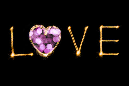 Love writing by sparkler firework isolated on black background for Valentines dayの写真素材