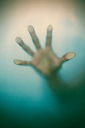Blurry hand behind matted glass in vintage tone