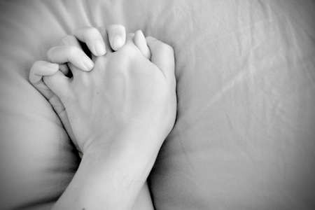 Making love in bed focus on hands in black & white tone - XXX conceptの写真素材
