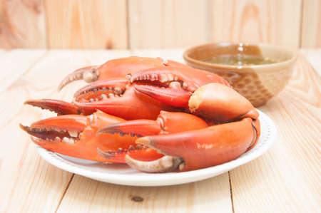 Boiled crab claws and seafood sauce in wooden backgroundの写真素材