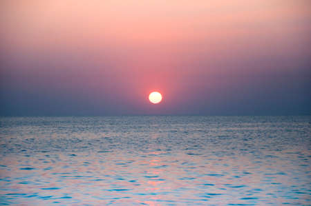Blurred sunset at the ocean in rose quartz and serenity tone
