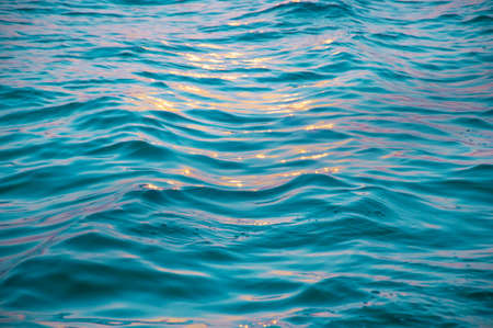 Yellow sunlight against close up sea wave surface