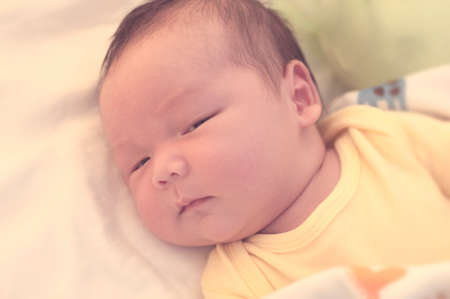 Baby looking a camera in blurred warm dreaming conceptの写真素材