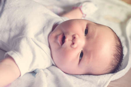 Selective focus of newborn baby boy looking somethings in blurred dreaming warm tone